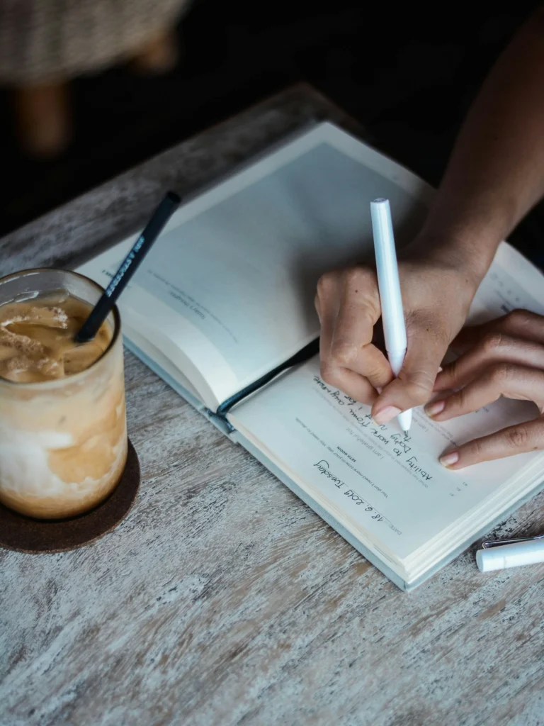 Persona practicando escritura terapéutica en un diario para gestionar la ansiedad y procesar miedos.