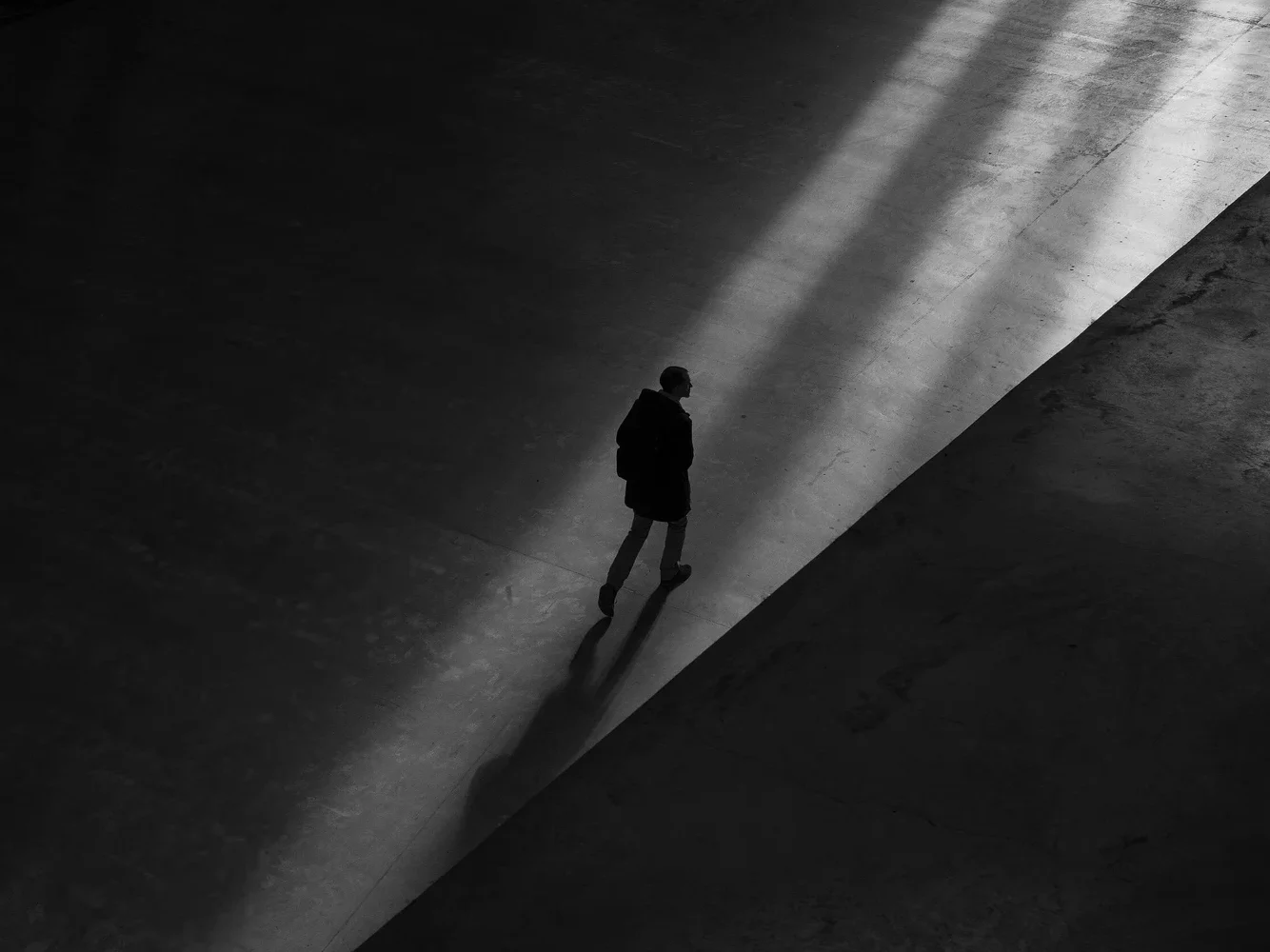 Silueta de una persona caminando por un espacio sombrío, representando la sensación de aislamiento y miedo que genera una fobia.