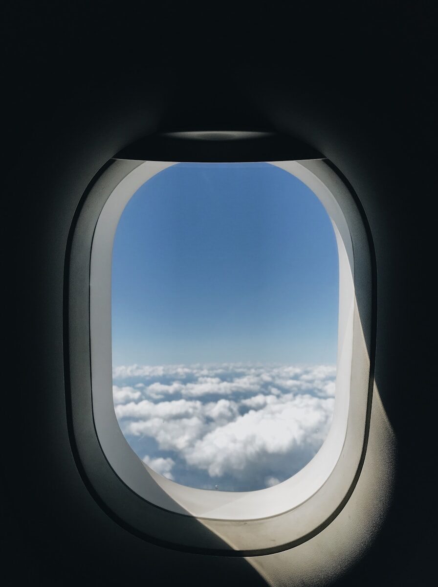 Vista desde la ventanilla de un avión entre nubes, simbolizando la superación del miedo a volar