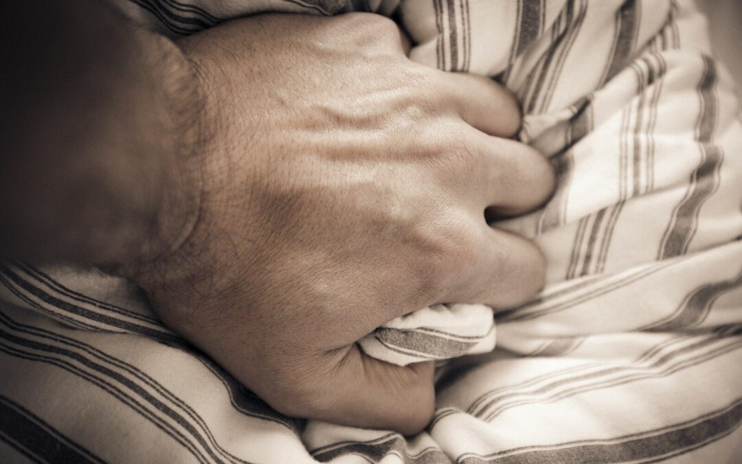 Persona con la mano en el pecho durante un ataque de pánico, sintiendo opresión torácica y falta de aire