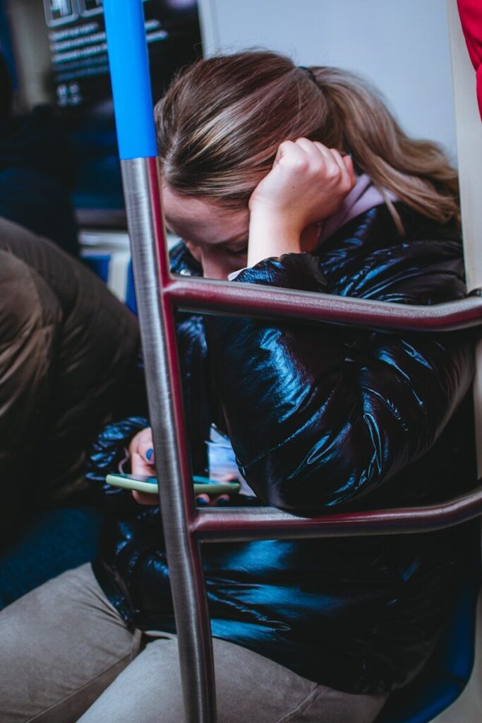Mujer apoyada y agobiada en un vagón de transporte público, situación que puede desencadenar un ataque de pánico con agorafobia asociada
